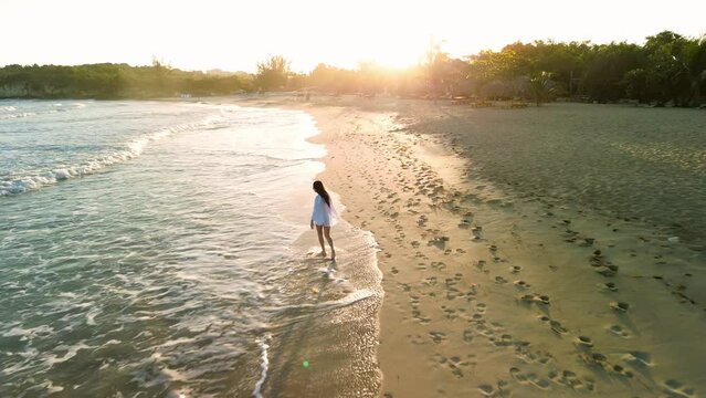 Girl walking at dawn on beach view from drone. Dominican Republic. Punta Cana