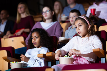 little female viewer sitting at premiere in cinema