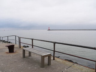 Rot-weiß gestreifter Leuchtturm an der Steuerbord Mole des Hafens Warnemünde vor der Ostsee