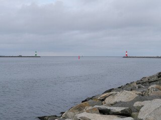 Grün-weiß und rot-weiß gestreifter Leuchtturm an der Mole des Hafens Warnemünde vor der Ostsee