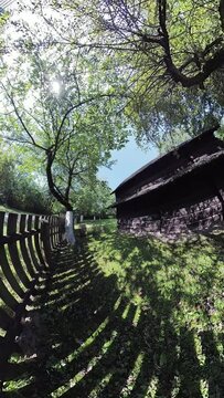 This video shows a traditional wooden house in a rural area. The house is surrounded by a wooden fence. The video is taken from a first-person perspective, and the viewer can see the house and its