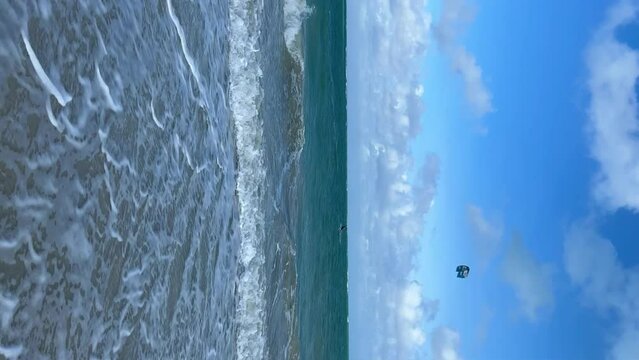 CUBA - DECEMBER 22: Kitesurfing in Varadero. Several people are kitesurfing on the beach on a cloudy day. Kites are lifted into the air by the wind. Tourists ride kiteboards in the turquoise ocean. 4К