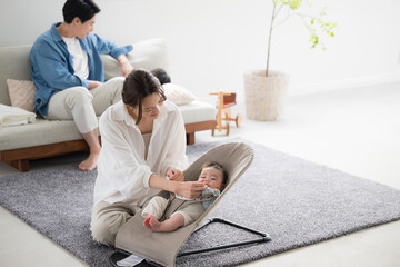 リビングで子育てをする4人アジア人（日本人）家族 見つめ合う赤ちゃんとお母さん