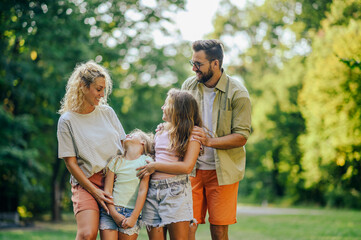 A happy family standing in nature and having good time together.