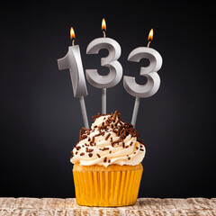 birthday cupcake with number 133 candle - Celebration on dark background