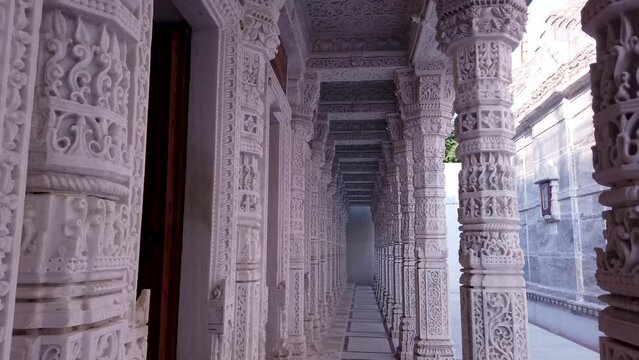 Udaipur, Rajasthan, India-October 30 2023; Artistically carved White marble pillars and wall exteriors of a Jain temple dedicated to Lord Mahavira and Parasnath at Udaipur in Rajasthan, India.
