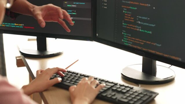 Slow motion back end or software developer manager supervising his team on new application program development on debugging and solving complex code algorithms on monitor. Burgeoning