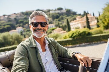 Happy middle-aged man with a big smile driving a beautiful classic car along a scenic coastal road on a bright and sunny day, surrounded by the breathtaking view of the sea and clear blue sky