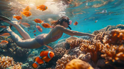 Fototapeten Young woman snorkeling dive underwater with Nemo fishes in the coral reef, women on vacation in Thailand © Fokke Baarssen