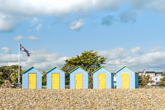 Beach huts in Eastbourne and British flag, East Sussex, English coastline.UK.