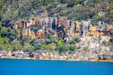 On the blue sea going past headlands and islands in Broken Bay