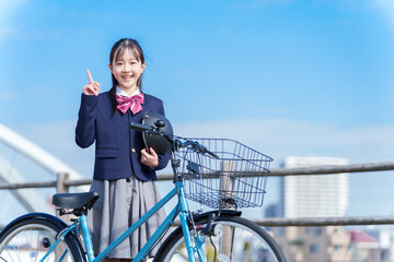 ヘルメットを持つ自転車に乗る女の子