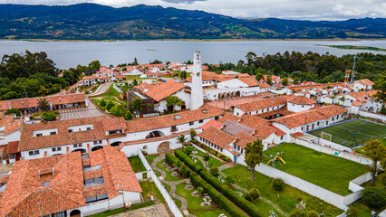 Aerial view of Guatavita, Cundinamarca with its iconic architecture, lush greenery, and serene lake