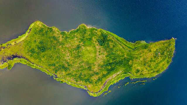 erial view of vibrant green landscape of Embalse de Tomin&eacute;, Guatavita, Cundinamarca, surrounded by dark blue waters