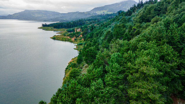 Scenic view of serene Tomin&eacute; Reservoir, Guatavita, surrounded by lush greenery under a cloudy sky