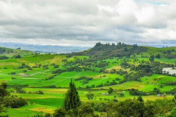 Fototapeta premium Breathtaking landscape of Guatavita, Cundinamarca with vibrant green fields and cloudy sky