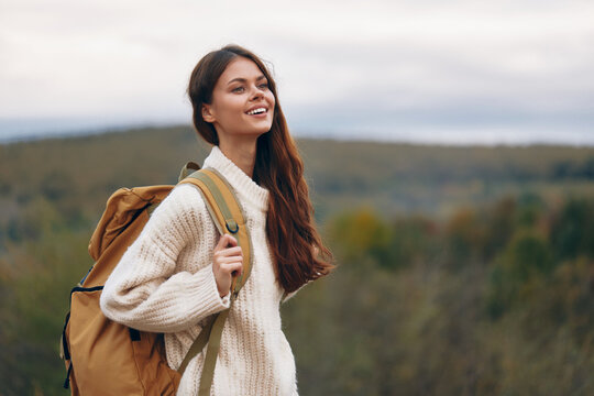 Adventurous Woman Smiling on Cliff, Enjoying Mountain Hiking Journey