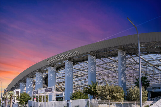 A beautiful spring landscape at SoFi Stadium with lush green palm trees and plants with powerful clouds at sunset in Inglewood California USA