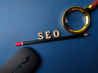 Top view pencil and word SEO with black magnifying glass