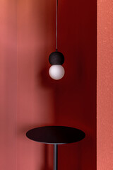 Pendant lamp with light bulb against dark red background
