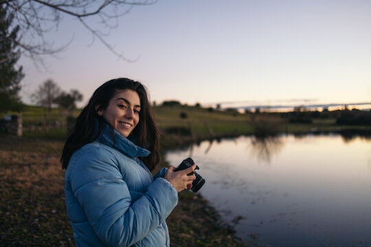 Photographer woman taking photos of a lake at sunset