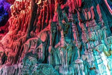 Zelfklevend Fotobehang Guilin Illuminated multicolored stalactites, Reed Flute cave. Guilin Guangxi. China
