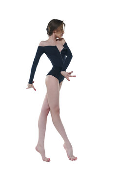 skinny ballerina in a black bodysuit poses in a photo studio showing dance moves