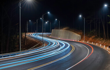 Night scene at the newly widened curved pass in Da Lat, Vietnam illuminated by the headlights of...