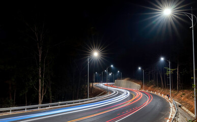 Night scene at the newly widened curved pass in Da Lat, Vietnam illuminated by the headlights of passing cars on a dark night to help traffic flow more smoothly when tourists come here