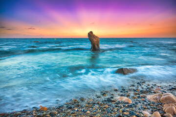 Landscape of rocky beach at sunset with ocean waves and pebbles on Co Thach beach, a famous beach...