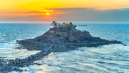 Morning sunrise landscape on Hon Ba island, Vung Tau, Vietnam with a small pagoda. People walking...