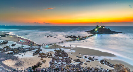 Morning sunrise landscape on Hon Ba island, Vung Tau, Vietnam with a small pagoda. People walking...