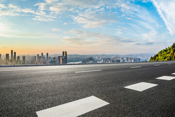 Asphalt highway road and city skyline with modern buildings at sunset in Chongqing. High Angle view.