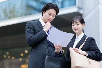 書類を確認するビジネスマンとビジネスウーマン