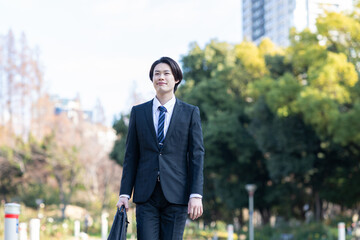 公園を歩くビジネスマン