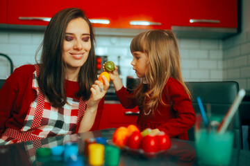 Mother and Daughter Knocking Easter Eggs Celebrating at Home. Traditional egg fight game celebrating spring religious holidays 
