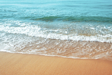 Fototapeta na wymiar Soft wave of the sea on the sandy beach. Toned.