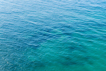 Fototapeta na wymiar Blue sea water surface texture background. Top view of the sea.
