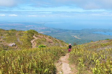 Fototapeta premium Young woman on the mombacho volcano trail admiring the view of the landscape.
