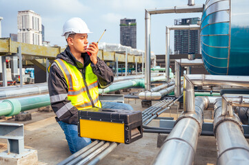 The image captures a skilled engineer inspecting a network of pipelines in a petrochemical...