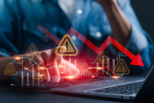 Economic crisis and global economic recession. Businessman use laptop analyze economic graph with warning sign for caution in investing economic situation warning, Business investment risks. - Powered by Adobe