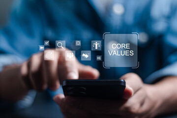Core values responsibility ethics goals company concept. Person using smartphone with Core Values icons on virtual screen.