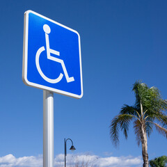 Blue Handicapped Parking Sign with Blue Sky, Palm Tree, Light Post and Clouds Background - obrazy, fototapety, plakaty