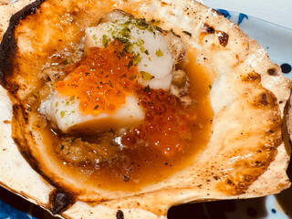 Baked scallops with red caviar on a plate.