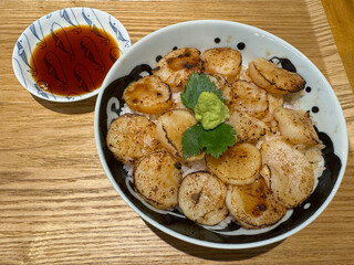 Grilled scallops with rice and soy sauce on wooden table