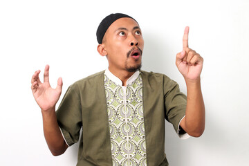 Excited Indonesian Muslim man in koko shirt and peci has an idea, raising his finger in a eureka...