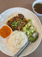 Beef stew served with barley and pickled cucumber.