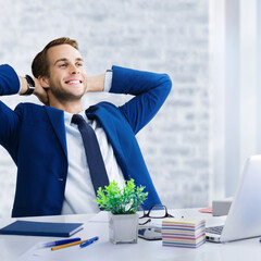 Relaxing or dreaming businessman with hands behind head. Business man in blue suit with laptop...
