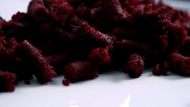 Close up of slow rotating beet pulp on a plate to make a beet pulp chocolate muffin