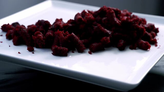 Beet muffin pulp on rotating platter on white plate to make red velvet beet pulp muffin